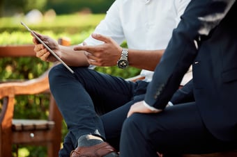 Two people talking on a bench
